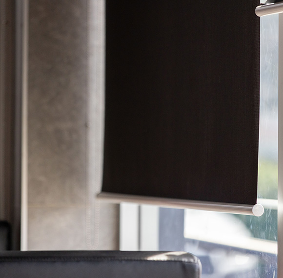 Roller blackout blind elegantly fitted to a window in a modern setting.
