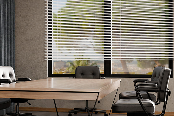 Fauxwood blinds covering a large window in a modern conference room.
