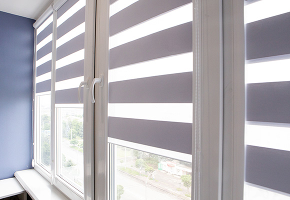 Day and night roller blinds fitted in a modern living room window.