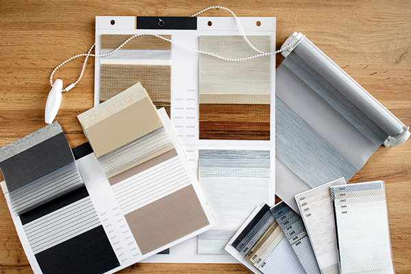 Blind fabric and material samples displayed on wooden surface for selection
