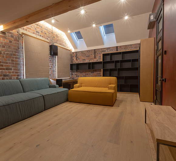 Fabric roller blinds in a modern living space with wooden flooring.