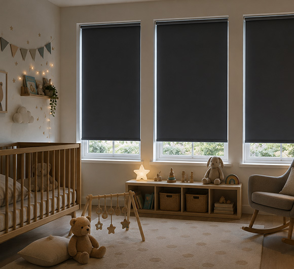 Blackout roller blinds in a cozy nursery with a crib and soft toys.