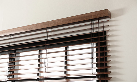 Fauxwood horizontal blinds installed above a window.