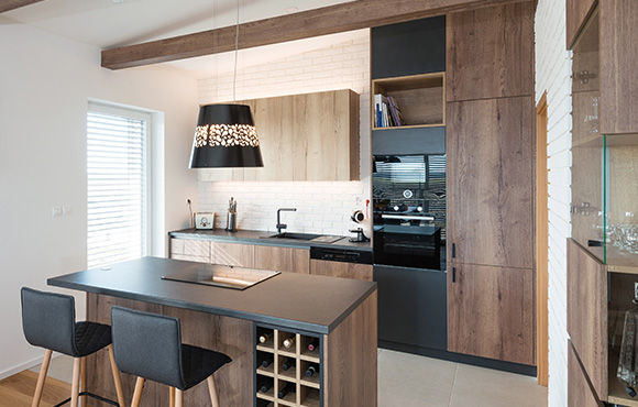 Modern kitchen with wooden cabinetry, pendant lighting, and window blinds.