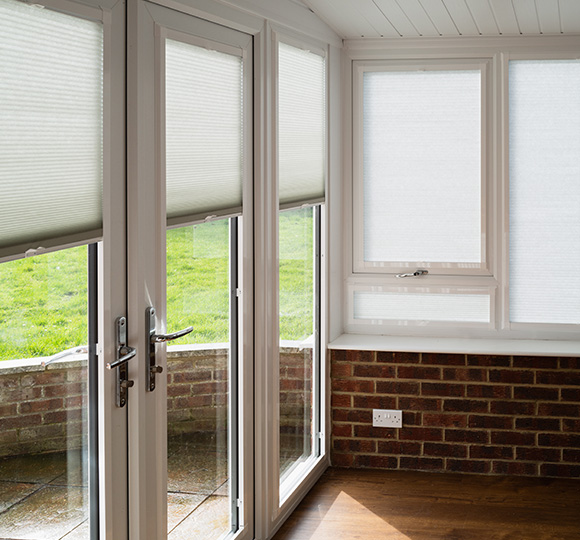 Light-filtering blinds installed on large windows in a sunlit room.