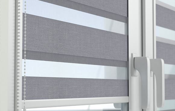 Gray day and night blinds installed on a window with white trim.